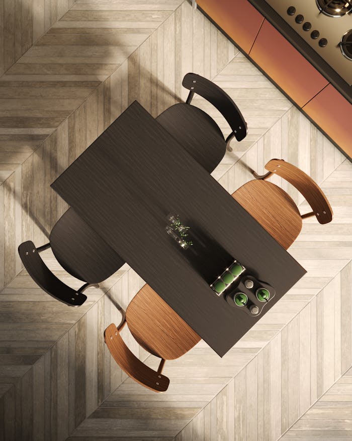 A top-down view of a stylish modern kitchen table with elegant chairs on chevron-patterned flooring.