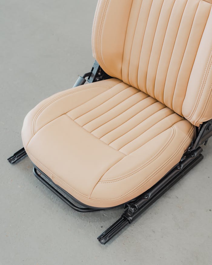 High-quality beige leather car seat with detailed stitching, perfect for modern interior design and automotive enthusiasts.